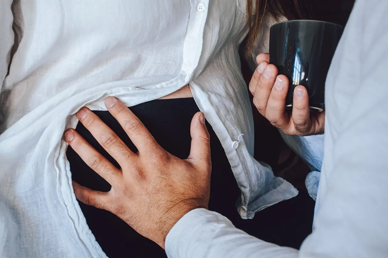 Hænder på mave og kop